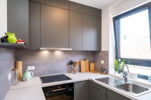 een keuken met grijze kasten, een wastafel en een raam bij Apartment Martina in Dubrovnik