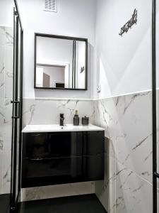 a bathroom with a sink and a mirror at Przytulny apartament przy Sokolskiej - 550 metrów od Spodka in Katowice