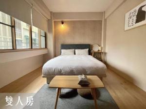 Dormitorio pequeño con cama y mesa en 度小日 en Tainan