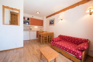 - un salon avec un canapé rouge et une table dans l'établissement le hameau des ecrins, à Puy-Saint-Vincent