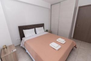 a bedroom with a large bed with two towels on it at Lovely 2-bedroom apartment with a city view (F10) in Piraeus