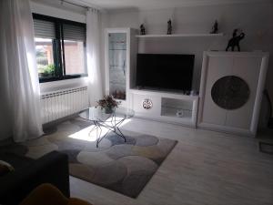a living room with a flat screen tv on a stand at Casa A Boleriña 2 in Combarro
