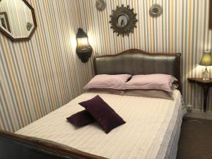 ein Bett mit zwei Kissen darauf in einem Schlafzimmer in der Unterkunft Villa L'enclos Des Lys in Saint-Georges-dʼOléron