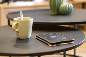 uma chávena de café e um telemóvel numa mesa em Nouveau - Au Fil de l'Eau - Terrasse em Barr