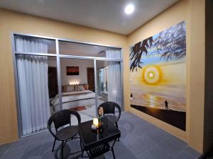 ein Esszimmer mit einem Tisch und Stühlen sowie ein Schlafzimmer in der Unterkunft Pool Villa, Resort, Mae Ramphueng Beach, Ban Phe, Rayong, Residence M Thailand in Ban Chamrung