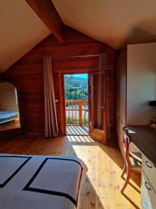 a bedroom with a bed and a large window at Le Chalet des Cévennes in La Plaine des Cafres