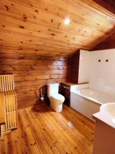 La salle de bains en bois est pourvue de toilettes et d'une baignoire. dans l'établissement Le Chalet des Cévennes, à La Plaine des Cafres