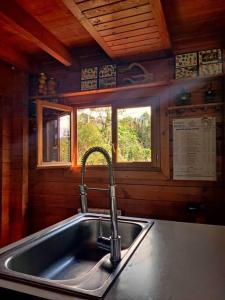 un fregadero de cocina en una cabaña con ventana en Le Chalet des Cévennes, en La Plaine des Cafres