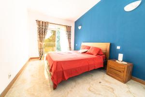 a blue bedroom with a bed with a red blanket at Tropicana Villa in Le Morne