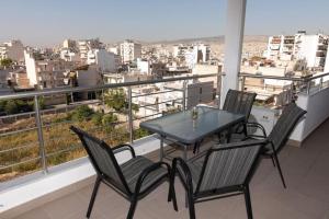 a table and chairs on a balcony with a view at Lovely 2-bedroom apartment with a city view (F10) in Piraeus