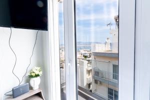 a room with a window with a view of a city at Aiolos loft sea view peiraiki in Piraeus