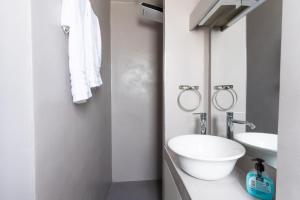 Baño blanco con lavabo y espejo en Aiolos loft sea view peiraiki en Piraeus