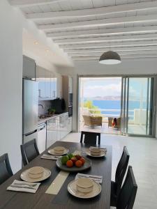 a kitchen and dining room with a table with fruit on it at Panoramic View Mykonos in Mýkonos City