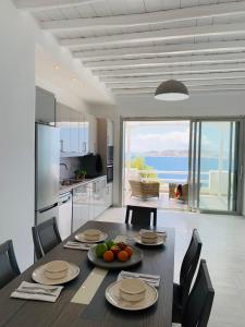 a kitchen and dining room with a table with fruit on it at Panoramic View Mykonos in Mikonos