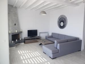 a living room with a couch and a tv at Panoramic View Mykonos in Mýkonos City