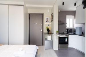 a bedroom with a bed and a kitchen with white cabinets at Aiolos loft sea view peiraiki in Piraeus
