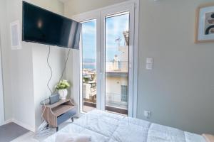 sypialnia z łóżkiem i dużym oknem w obiekcie Aiolos loft sea view peiraiki w Pireusie