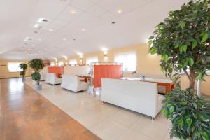 a waiting room with white chairs and potted plants at Hotel Reśliński in Grodzisk Wielkopolski