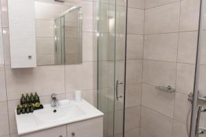 a bathroom with a shower and a sink and a mirror at Lovely 2-bedroom apartment with a city view (F10) in Piraeus