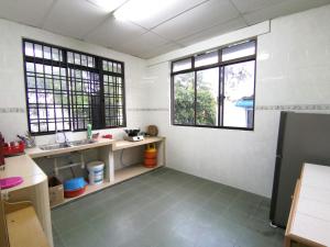 a kitchen with a sink and two windows at Cosy Homestay Ulu Tiram in Ulu Tiram