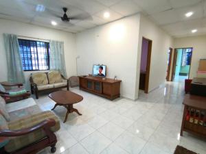 a living room with a couch and a table at Cosy Homestay Ulu Tiram in Ulu Tiram