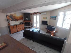 a living room with a couch and a television at Maison calme et lumineuse in Cierp