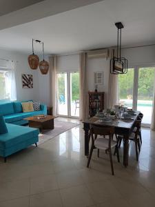 a living room with a table and a blue couch at Villa Evridiki in Georgioupolis