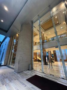 a lobby of a building with a large stone pillar at Luxury Apartemen Grand Lagoon Sungkono Surabaya in Dukuhpakis