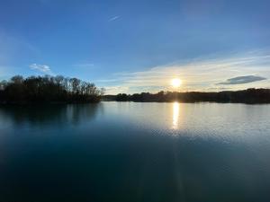 a view of a large lake with the sun setting at Loft-Apartment Schloßsee in Salem