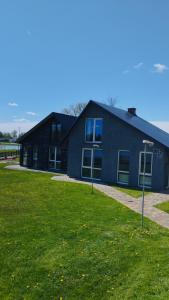 a building with a grass field in front of it at Add Story Guest House in Rēzekne