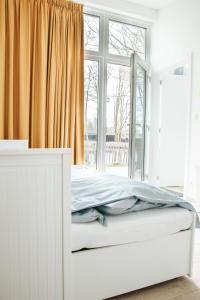 HammeにあるTrendy chalet aan visvijverの窓付きの客室の白いベッド1台