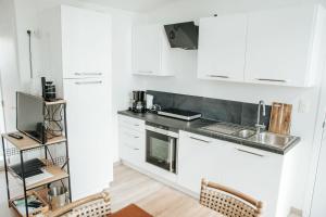 Hamme的住宿－Trendy chalet aan visvijver，厨房配有白色橱柜和水槽