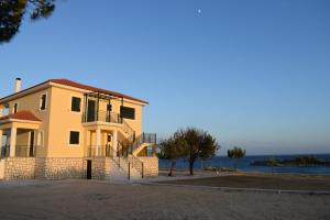 a house on the beach with the ocean in the background at CASA DEL MARE in Lixouri