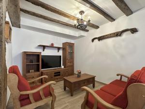 a living room with red chairs and a flat screen tv at Casa Rural Sutegia in Ziga