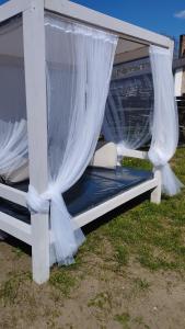 a bed under a gazebo with white curtains at Add Story Guest House in Rēzekne