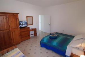 een slaapkamer met een bed, een tv en een dressoir bij Villa Bronja Superior Airconditioned Studio apartment in Xlendi in Xlendi