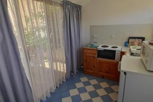 a kitchen with a stove and a window with curtains at Villa Bronja Superior Airconditioned Studio apartment in Xlendi in Xlendi