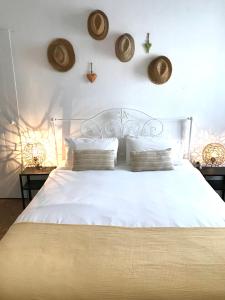 a bedroom with a white bed with hats on the wall at Casa Largo do Poço Guesthouse in Alvor