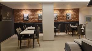 a dining room with tables and chairs and brick walls at Hotel The Classic in Ulsan