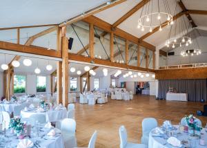 a banquet hall with white tables and white chairs at Hotel Weserschlösschen in Nienburg