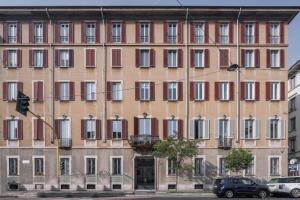 a large building with many windows on a street at Sant'Ambrogio Luxury Apartment R&R in Milan