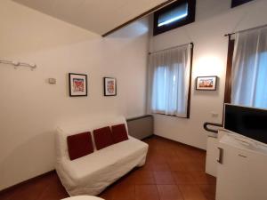 een woonkamer met een witte bank en een televisie bij La Loggia Vicenza in Vicenza