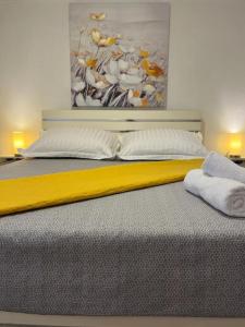 a bed with two pillows and a painting on the wall at BayStay in Kaštela