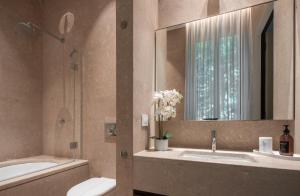 a bathroom with two sinks and a tub and a mirror at Sant'Ambrogio Luxury Apartment R&R in Milan +31 photos