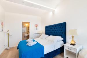 - une chambre avec un lit bleu et des serviettes dans l'établissement The Attico, à Sorrente