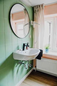 a bathroom with a sink and a mirror at sleepArt room for 1 in Celle