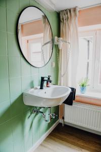 ein Badezimmer mit Waschbecken und Spiegel in der Unterkunft sleepArt room for 1 in Celle