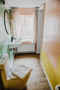 y baño con lavabo, espejo y aseo. en sleepArt room for 1, en Celle