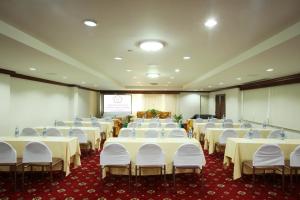 una sala de conferencias con mesas blancas y sillas blancas en Thumrin Hotel, en Trang