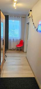 a room with a red chair and a window at Route66 apartament by Karl in Radom